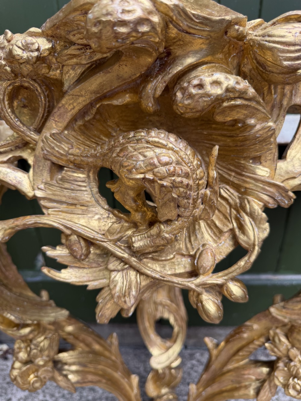 An 18th-century style French carved giltwood wall console table featuring intricate foliage, a central bird motif, and a variegated pink and ochre Breche dAlep marble top. View XX