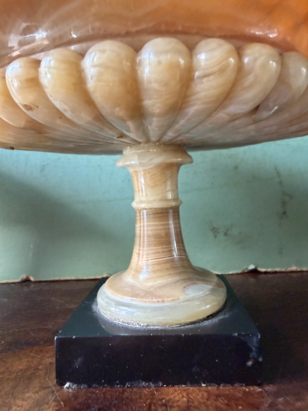 A pair of 19th-century carved amber alabaster tazze with gadrooned rims and twin loop handles set on square black marble plinths. View XVII
