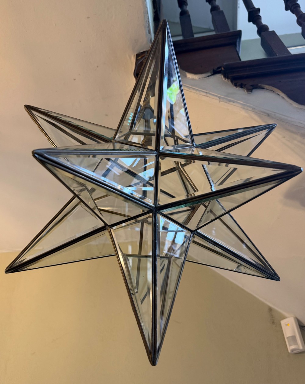 An early twentieth-century twelve-point Moravian star pendant lantern featuring a brass frame with clear bevelled glass panels and a chain drop. View V