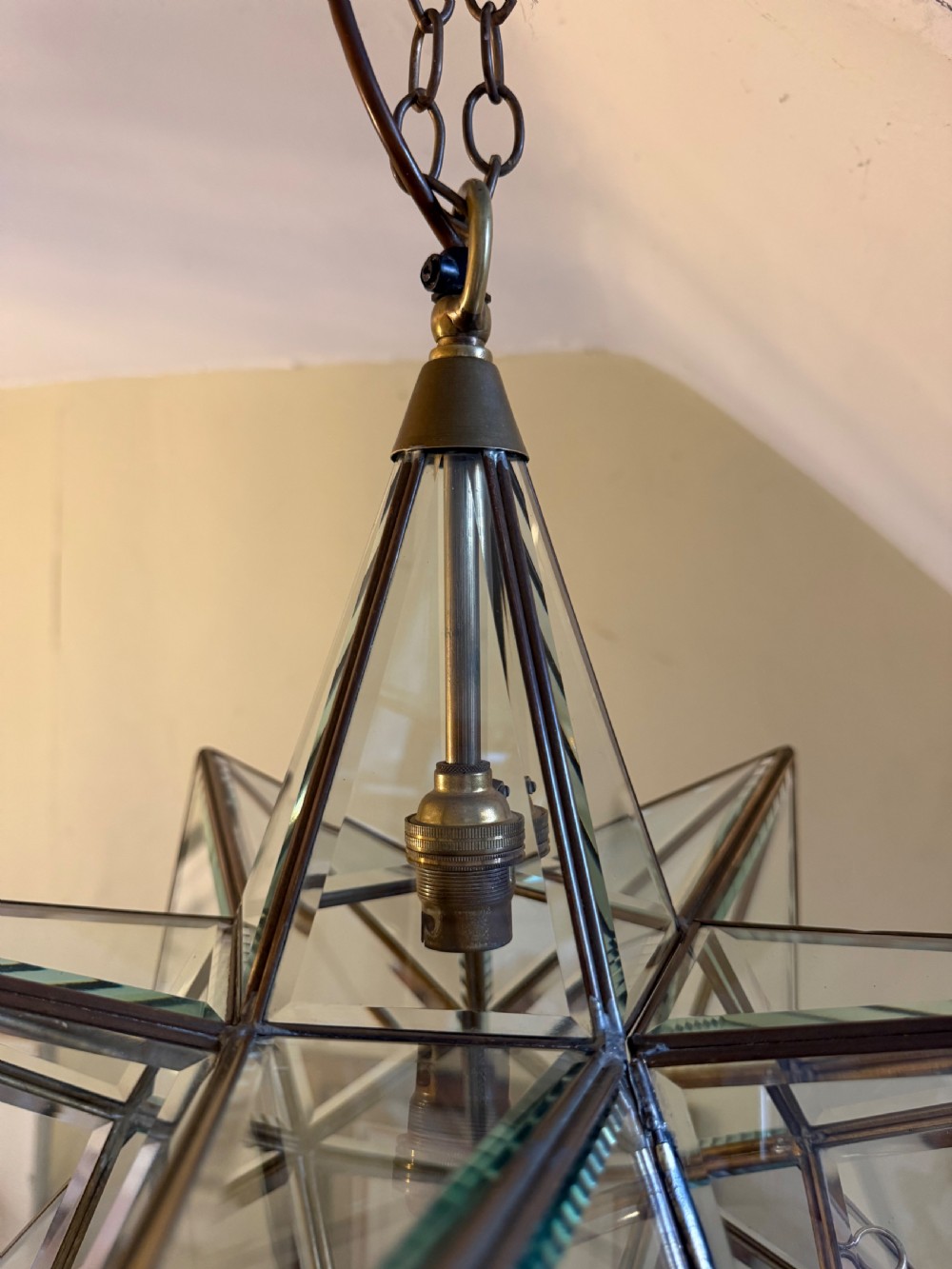 An early twentieth-century twelve-point Moravian star pendant lantern featuring a brass frame with clear bevelled glass panels and a chain drop. View VI