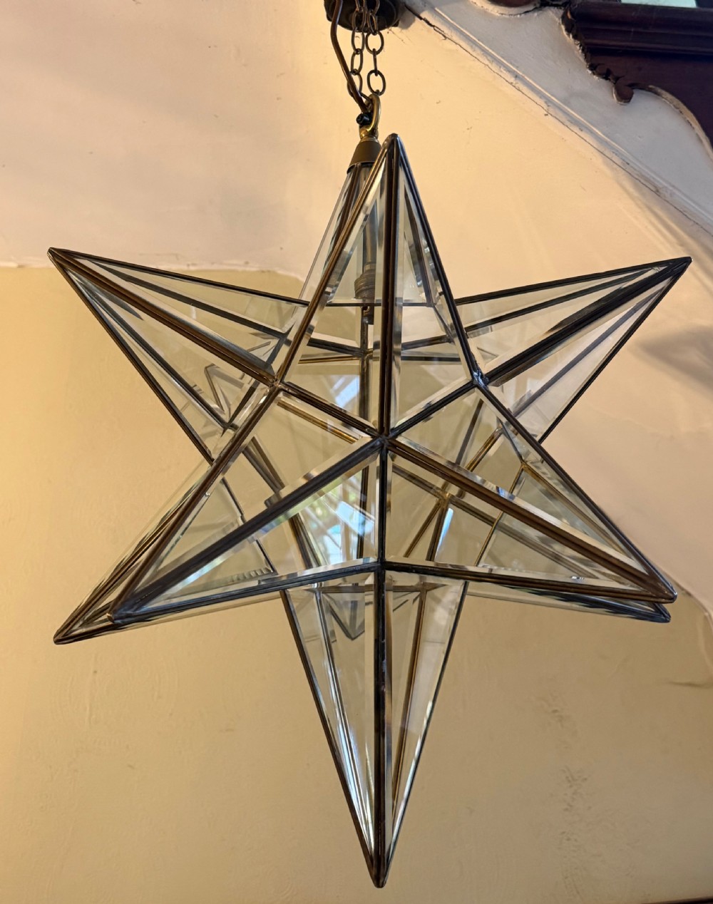 An early twentieth-century twelve-point Moravian star pendant lantern featuring a brass frame with clear bevelled glass panels and a chain drop. View X