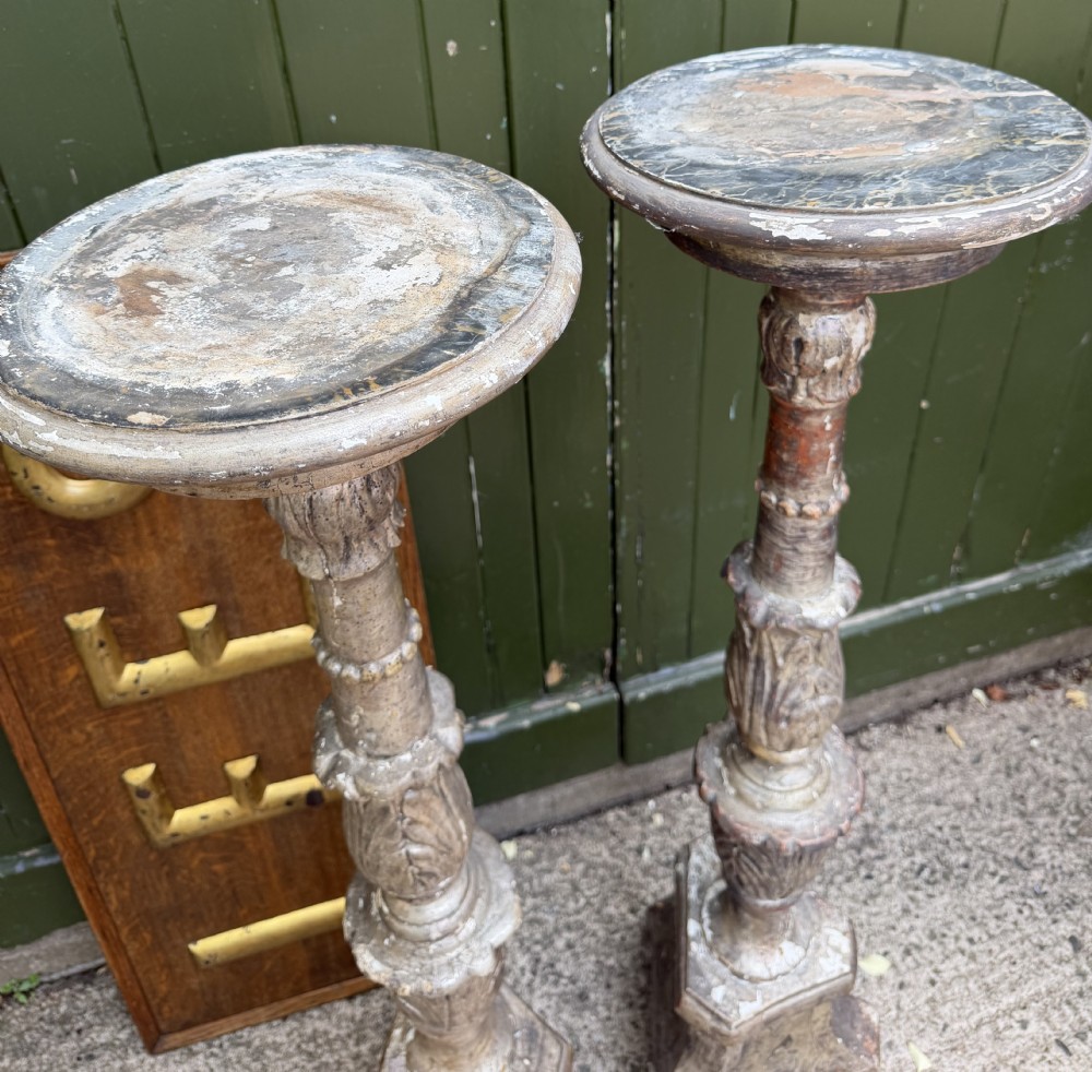 A pair of tall 18th-century Italian carved wood torcheres featuring baluster turned shafts with acanthus leaf details and an aged silver leaf finish. View XVIII