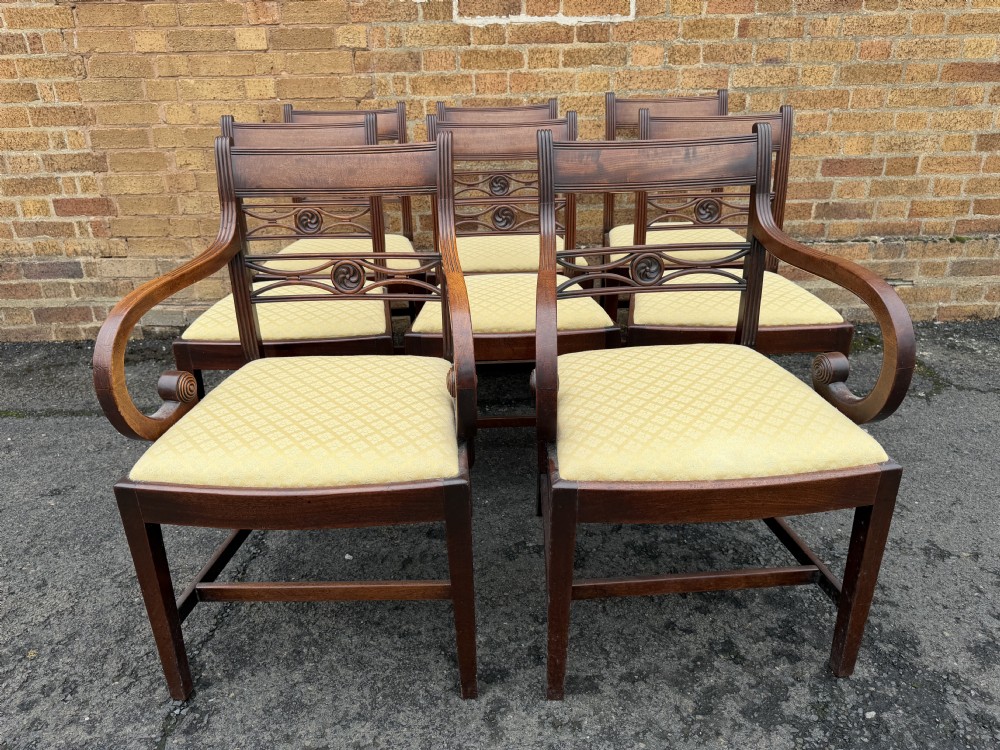 A set of eight late eighteenth-century George III mahogany dining chairs, comprising six side chairs and two armchairs with carved back rails and patterned yellow upholstered seats. View IV