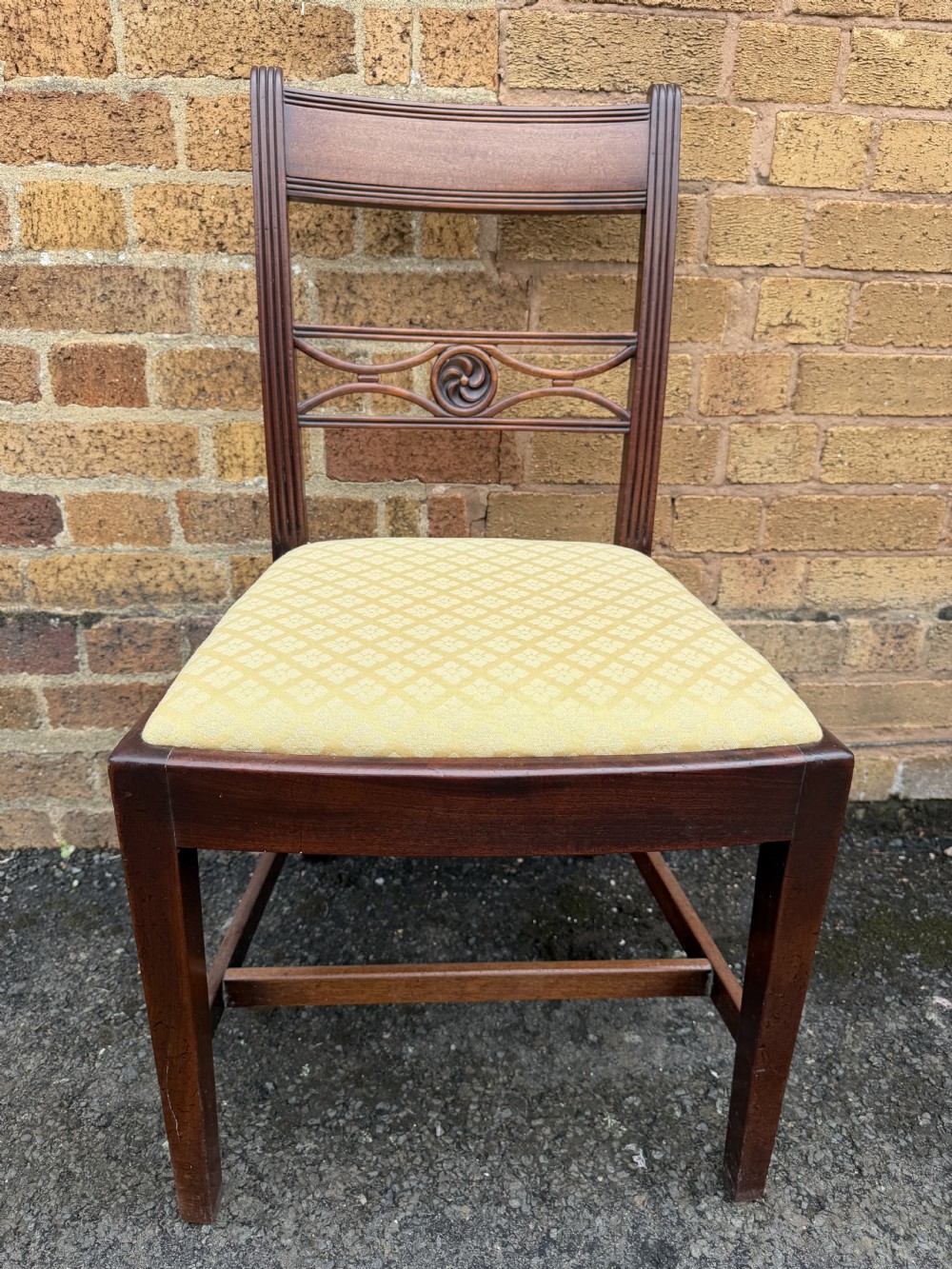 A set of eight late eighteenth-century George III mahogany dining chairs, comprising six side chairs and two armchairs with carved back rails and patterned yellow upholstered seats. View VIII