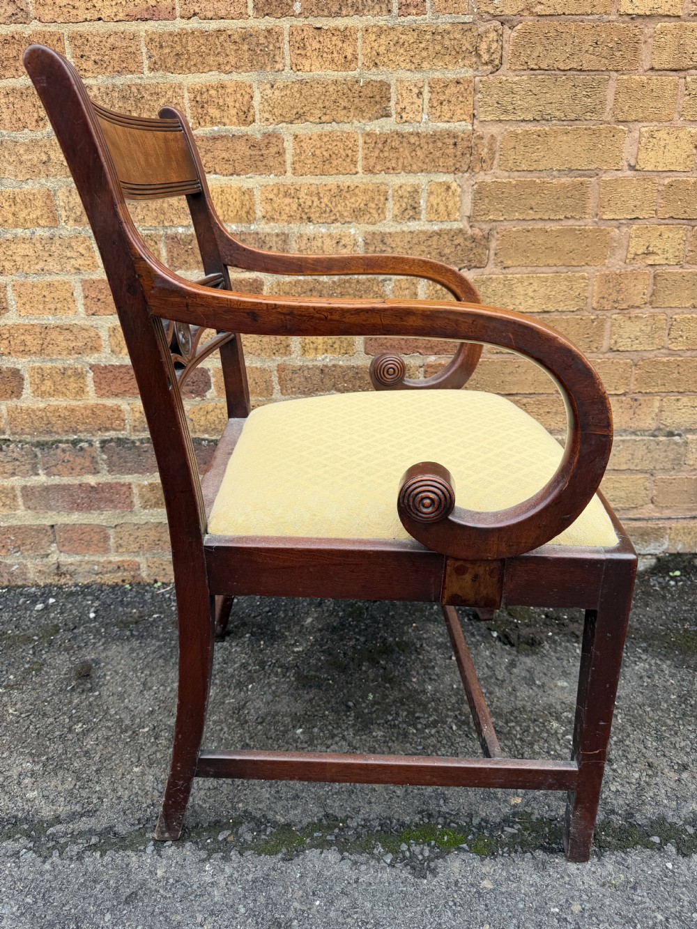 A set of eight late eighteenth-century George III mahogany dining chairs, comprising six side chairs and two armchairs with carved back rails and patterned yellow upholstered seats. View X