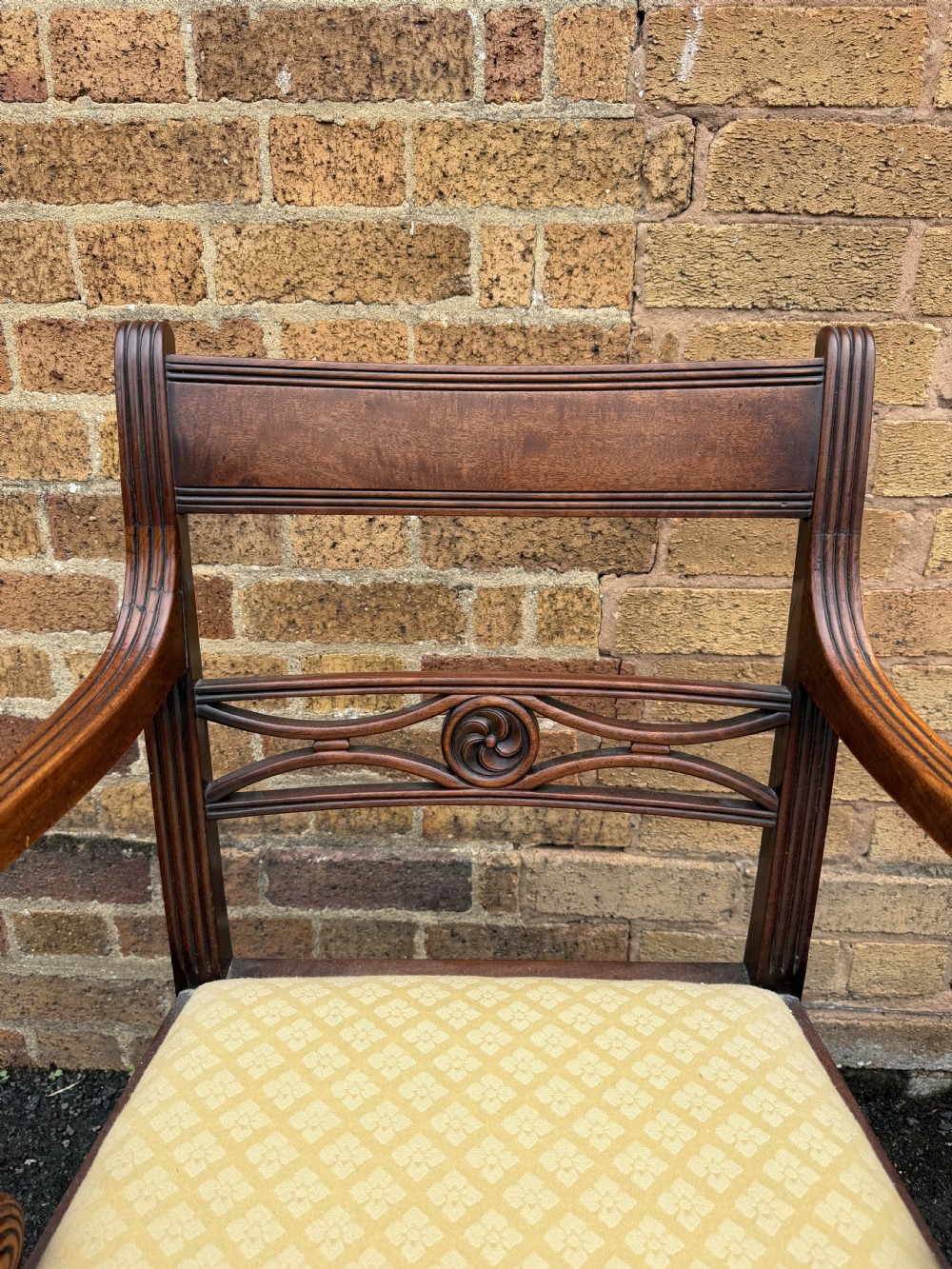 A set of eight late eighteenth-century George III mahogany dining chairs, comprising six side chairs and two armchairs with carved back rails and patterned yellow upholstered seats. View XII