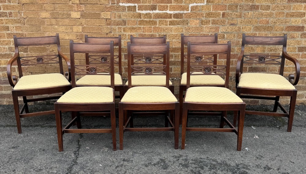 A set of eight late eighteenth-century George III mahogany dining chairs, comprising six side chairs and two armchairs with carved back rails and patterned yellow upholstered seats. View XV