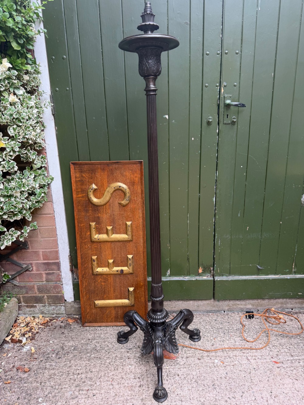 A tall late nineteenth-century cast-iron standard lamp with a dark bronze patinated finish, featuring a fluted column shaft, acanthus leaf moulding, and a tripod claw foot base.