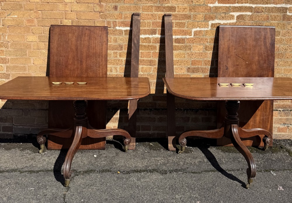 An early 19th-century George III twin-pillar mahogany dining table featuring reeded splayed legs and original brass castors. View XX