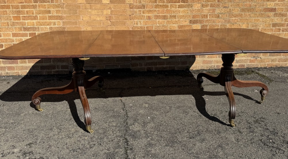 An early 19th-century George III twin-pillar mahogany dining table featuring reeded splayed legs and original brass castors. View XXIII