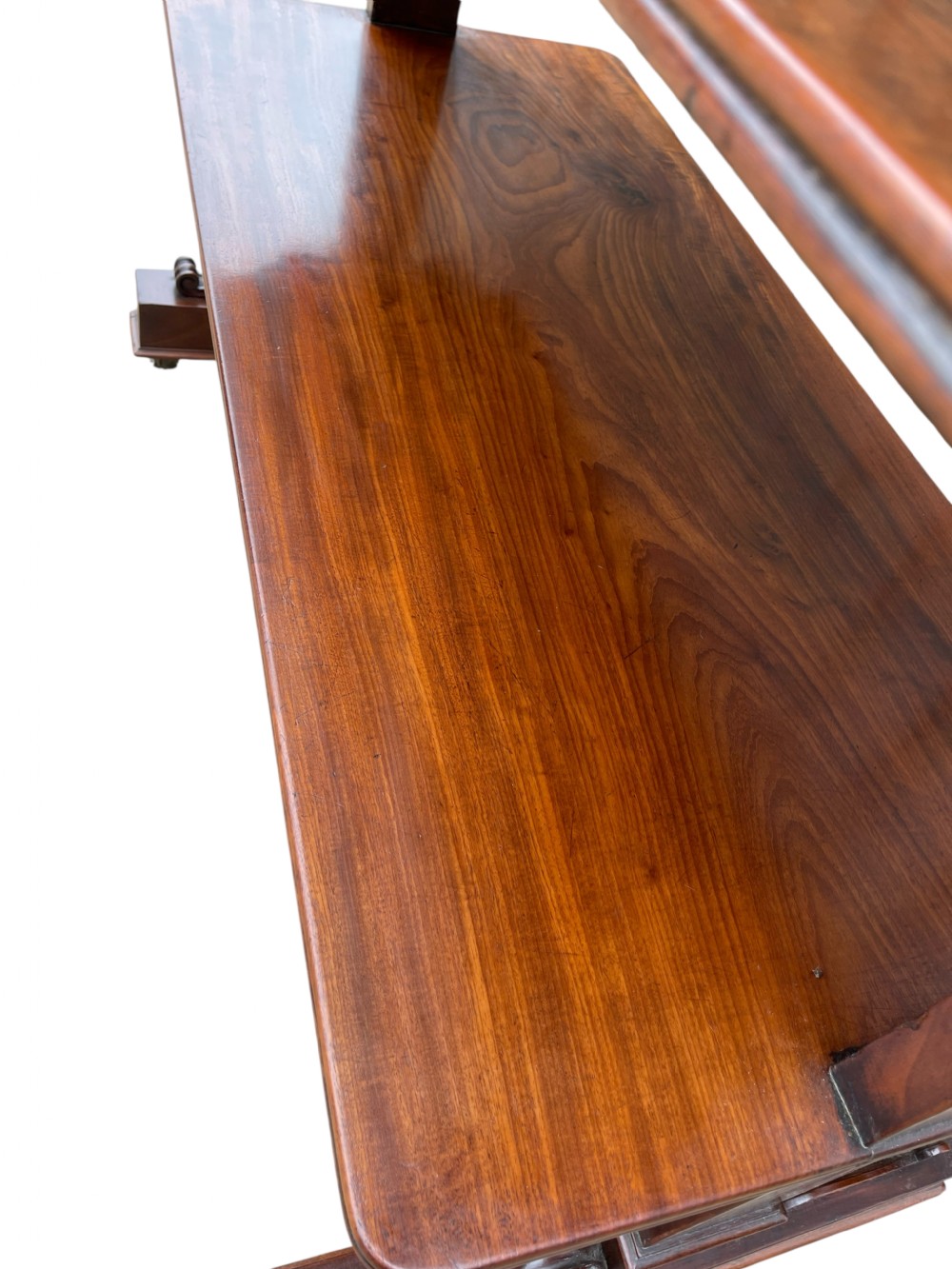 A nineteenth-century mahogany three-tiered dumb waiter featuring carved side uprights and fitted with brass castors at the base. View II