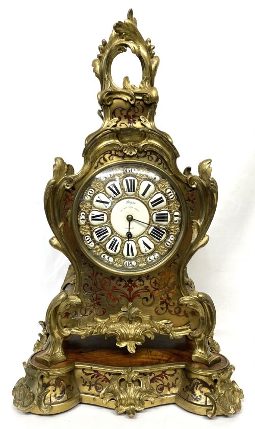 fig 1. An ornate Rococo Revival mantel clock featuring brass and tortoiseshell Boulle marquetry inlay, gilt mounts, and individual white enamel cartouche Roman numerals on a matching plinth base.