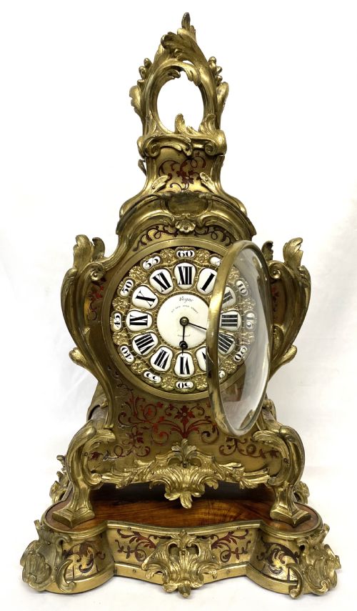 fig 3. An ornate Rococo Revival mantel clock featuring brass and tortoiseshell Boulle marquetry inlay, gilt mounts, and individual white enamel cartouche Roman numerals on a matching plinth base.
