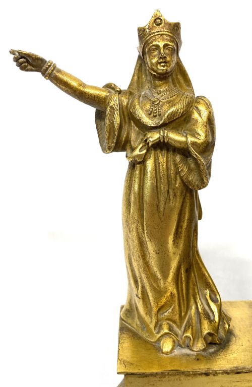 fig 1. A nineteenth-century French gilt bronze mantel clock featuring a standing female figure beside a square clock casing surmounted by scales of justice.