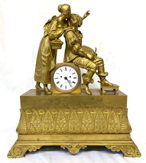 fig 1. A nineteenth-century gilt bronze figural mantel clock depicting a seated artist and companion figure above a white enamel dial with Roman numerals.