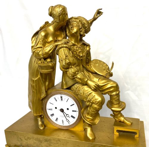 fig 3. A nineteenth-century gilt bronze figural mantel clock depicting a seated artist and companion figure above a white enamel dial with Roman numerals.