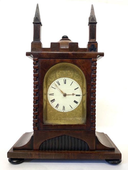 fig 3. A miniature architectural mahogany mantel clock with corner spires, a domed roof, and an engraved brass dial with Roman numerals.