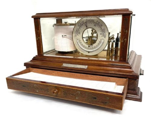 fig 1. An Art Nouveau mahogany barograph featuring a glazed display case, stylized inlay on the timber frame and base drawer, an internal recording drum, and a silvered barometer dial.