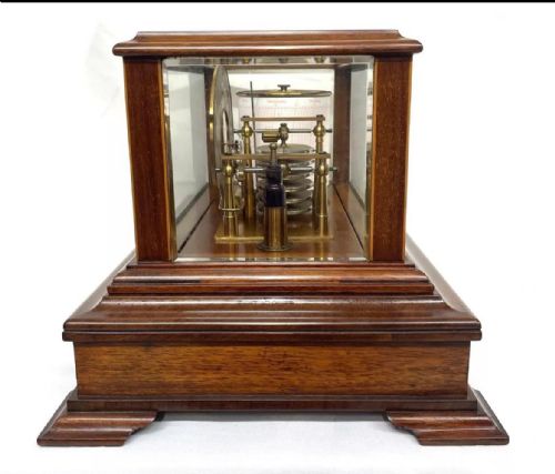fig 3. An Art Nouveau mahogany barograph featuring a glazed display case, stylized inlay on the timber frame and base drawer, an internal recording drum, and a silvered barometer dial.