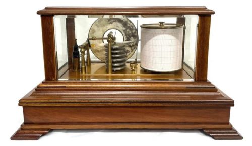 fig 4. An Art Nouveau mahogany barograph featuring a glazed display case, stylized inlay on the timber frame and base drawer, an internal recording drum, and a silvered barometer dial.