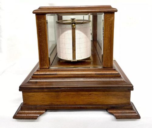 fig 5. An Art Nouveau mahogany barograph featuring a glazed display case, stylized inlay on the timber frame and base drawer, an internal recording drum, and a silvered barometer dial.