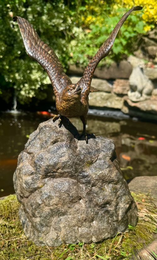 fig 2. A cold-painted bronze sculpture depicting a hawk with open wings perched atop a natural quartz stone base.