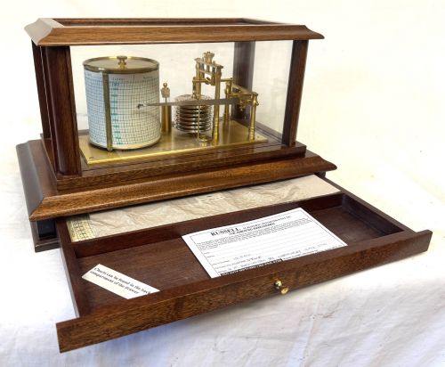 fig 1. An antique mahogany and brass barograph housed inside a rectangular glazed display case with an internal paper chart drum.