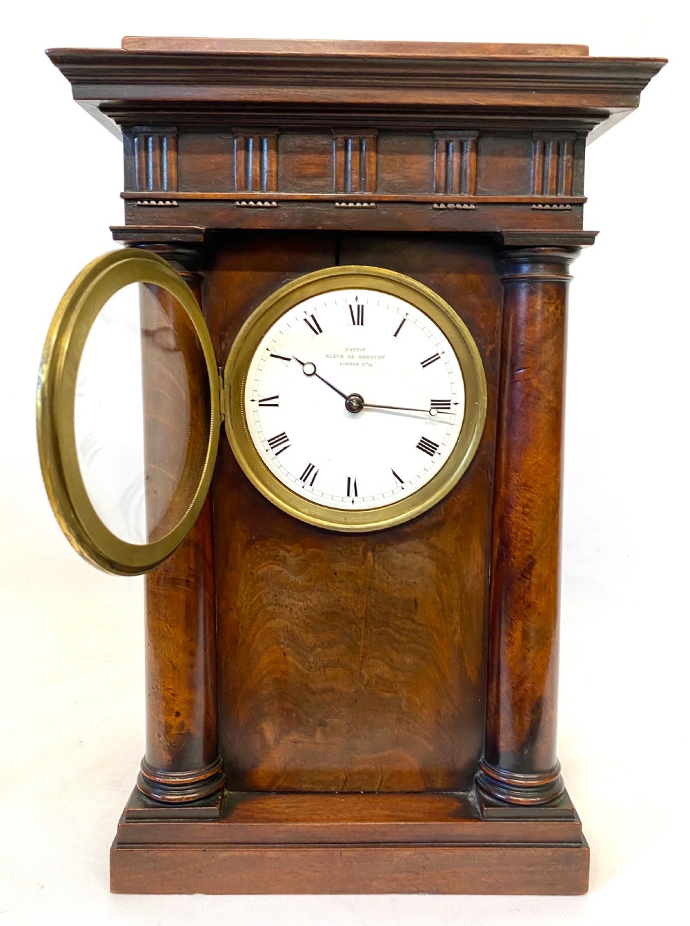 An early 19th-century Empire period Cuban mahogany mantel clock featuring an architectural case supported by four columns around a circular white enamel dial. View II