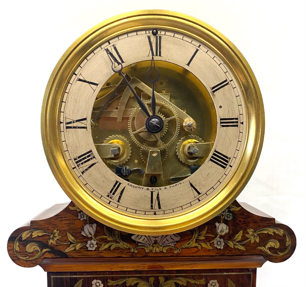 A 19th-century French rosewood mantel clock featuring intricate floral inlay, a top circular brass dial with exposed mechanism, and a central built-in thermometer. View III