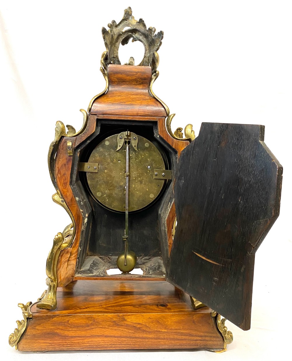 An ornate Rococo Revival mantel clock featuring brass and tortoiseshell Boulle marquetry inlay, gilt mounts, and individual white enamel cartouche Roman numerals on a matching plinth base. View XI