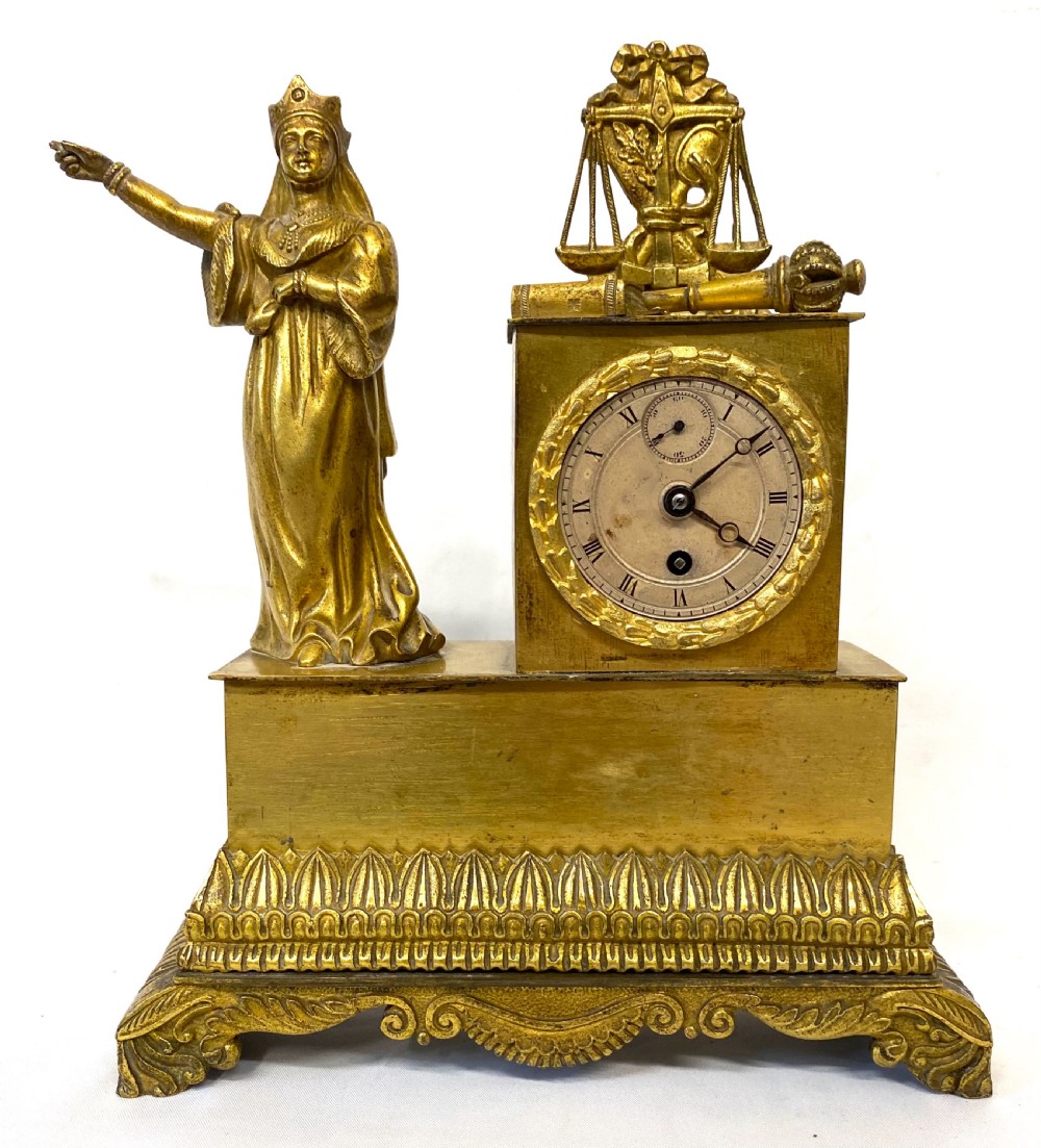 A nineteenth-century French gilt bronze mantel clock featuring a standing female figure beside a square clock casing surmounted by scales of justice. View III
