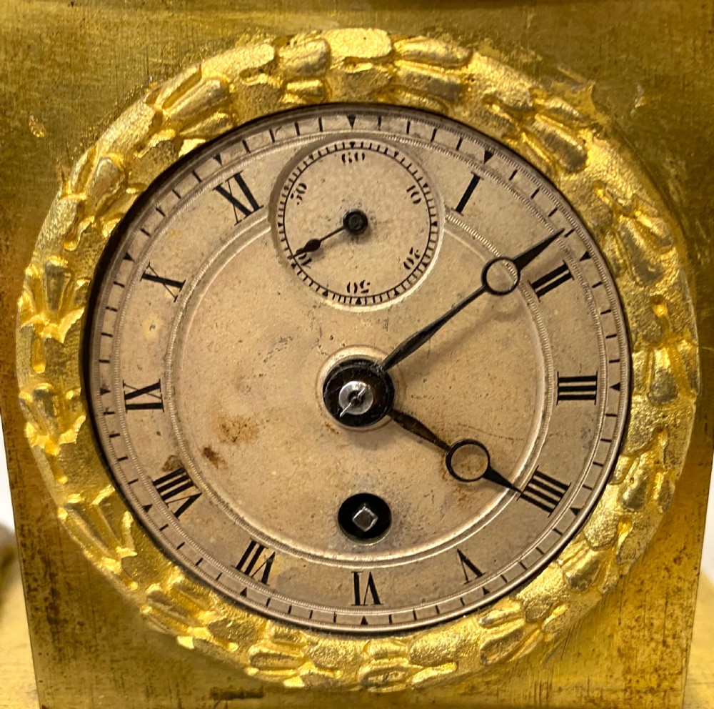 A nineteenth-century French gilt bronze mantel clock featuring a standing female figure beside a square clock casing surmounted by scales of justice. View VI