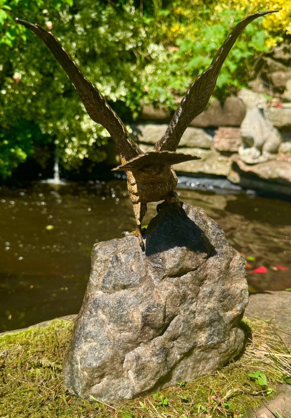 A cold-painted bronze sculpture depicting a hawk with open wings perched atop a natural quartz stone base. View XII