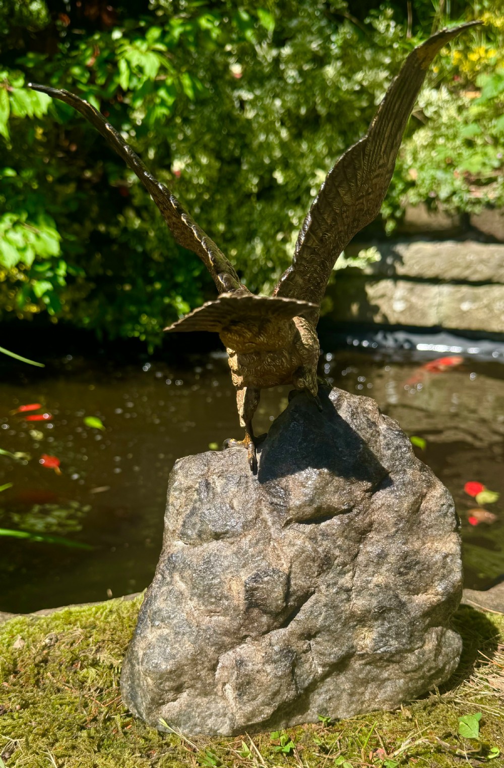 A cold-painted bronze sculpture depicting a hawk with open wings perched atop a natural quartz stone base. View XIII
