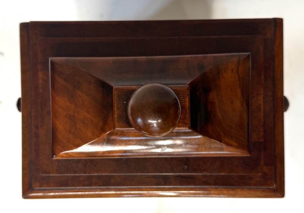 A mahogany single fusee mantel clock featuring a turned finial top, carved fan spandrels, a white dial with Roman numerals signed J Kingerley Manchester, and bun feet. View XI