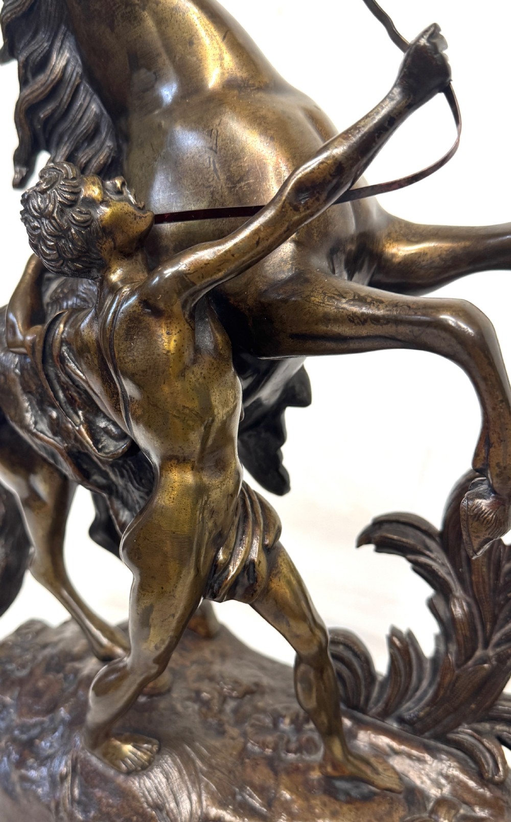 A pair of dark patinated bronze equestrian sculptures depicting rearing horses restrained by grooms on naturalistic rockwork bases. View XIII