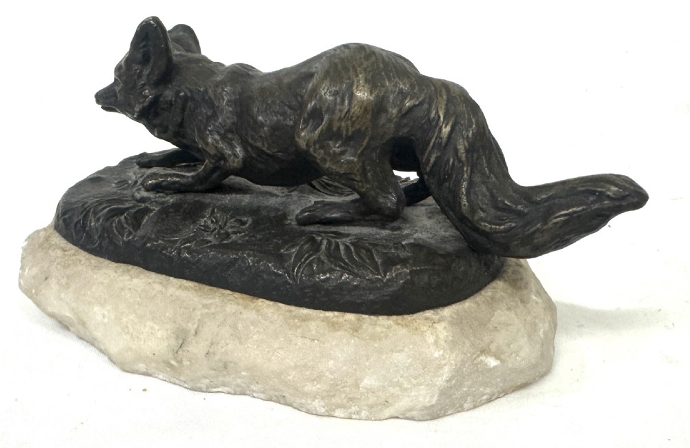 An antique dark bronze sculpture of a prowling fox set upon a naturalistic metal mound atop a cream marble base. View III