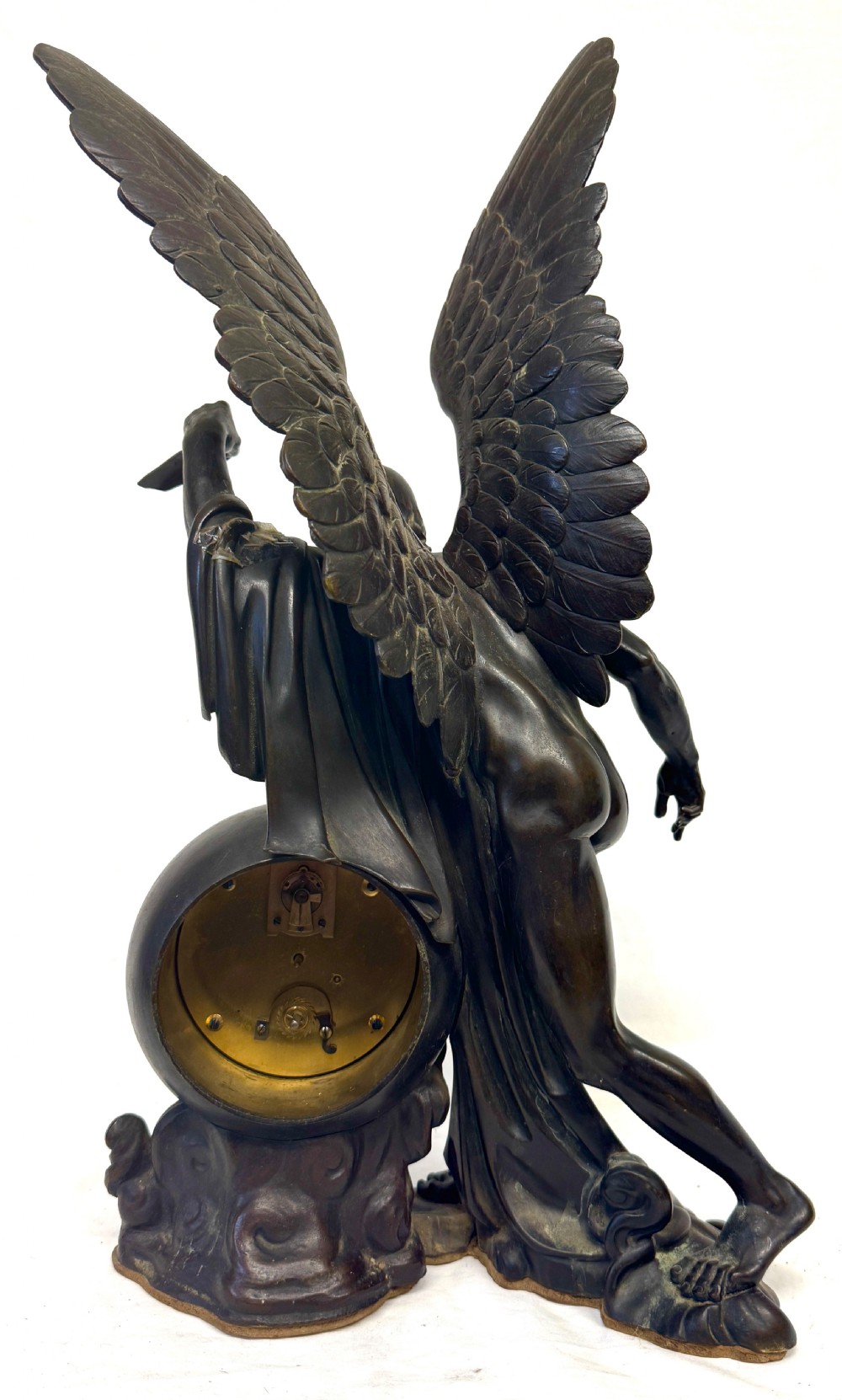 A dark bronze sculptural mantel clock featuring a winged figure of Father Time holding a scythe alongside a round clock face with Roman numerals. View VI
