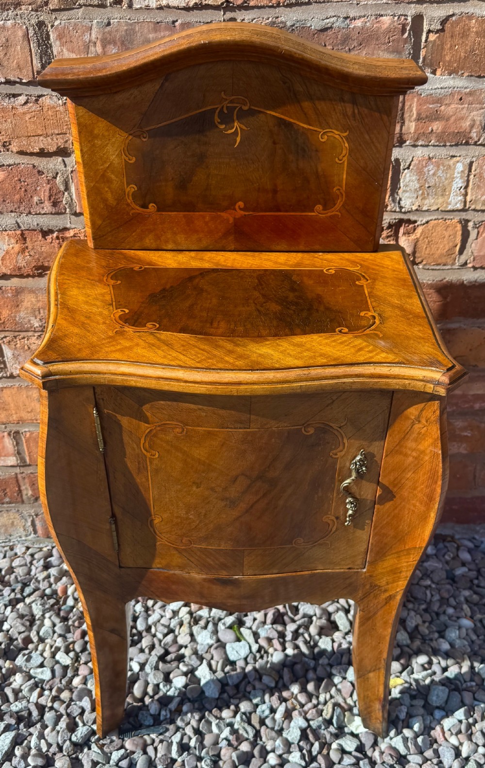A pair of antique inlaid satinwood bedside cabinets featuring curved sides, decorative marquetry, shaped top galleries, and single doors with ornate brass handles. View III