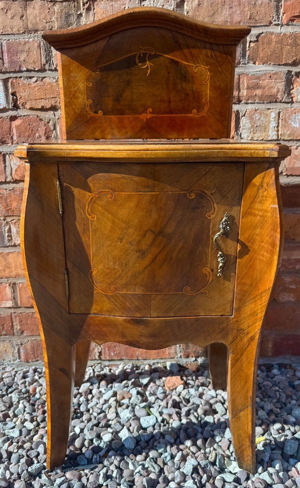 A pair of antique inlaid satinwood bedside cabinets featuring curved sides, decorative marquetry, shaped top galleries, and single doors with ornate brass handles. View IV