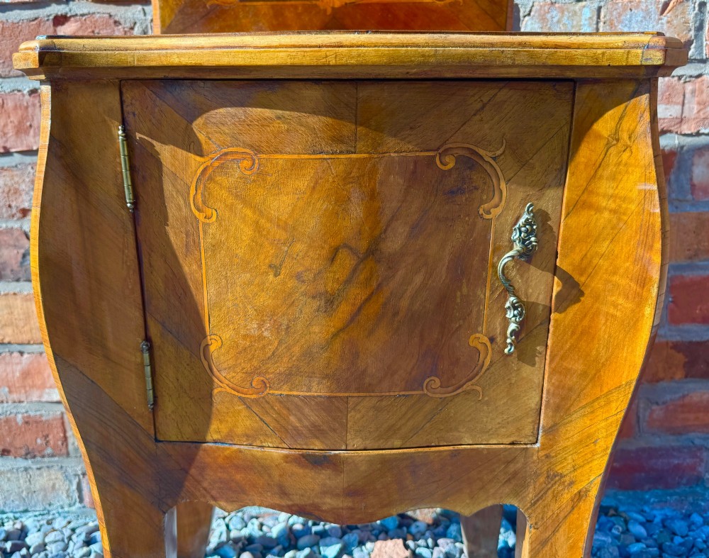 A pair of antique inlaid satinwood bedside cabinets featuring curved sides, decorative marquetry, shaped top galleries, and single doors with ornate brass handles. View VII