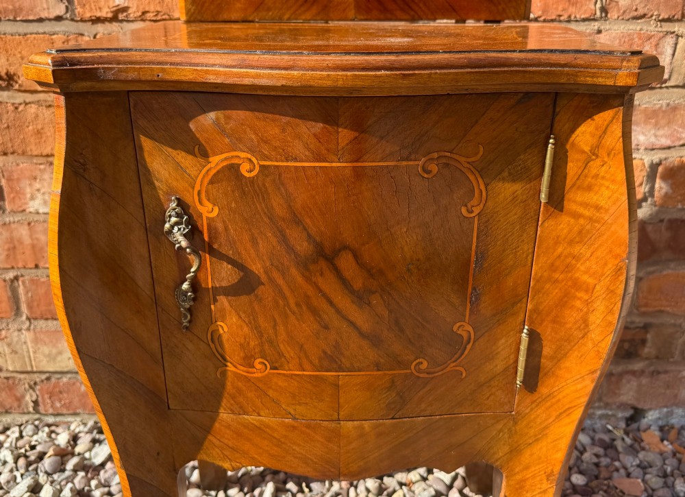A pair of antique inlaid satinwood bedside cabinets featuring curved sides, decorative marquetry, shaped top galleries, and single doors with ornate brass handles. View XIV