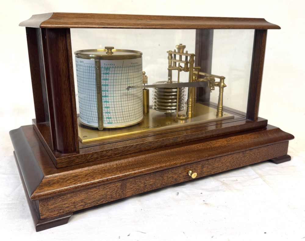 An antique mahogany and brass barograph housed inside a rectangular glazed display case with an internal paper chart drum.
