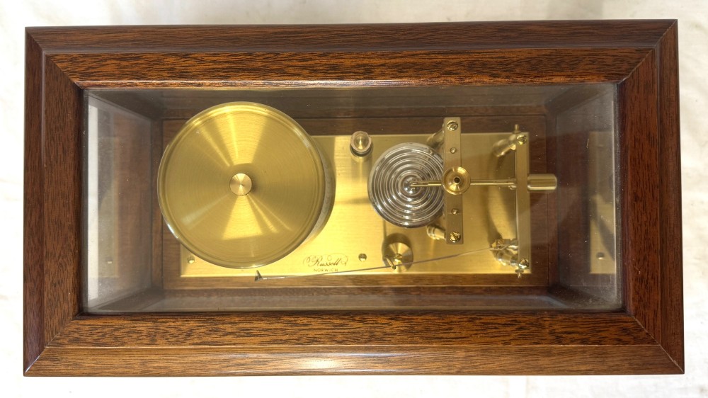 An antique mahogany and brass barograph housed inside a rectangular glazed display case with an internal paper chart drum. View VII