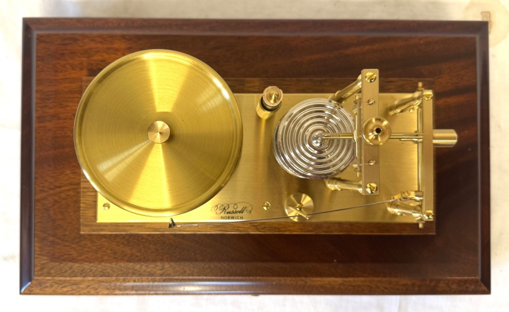 An antique mahogany and brass barograph housed inside a rectangular glazed display case with an internal paper chart drum. View XII