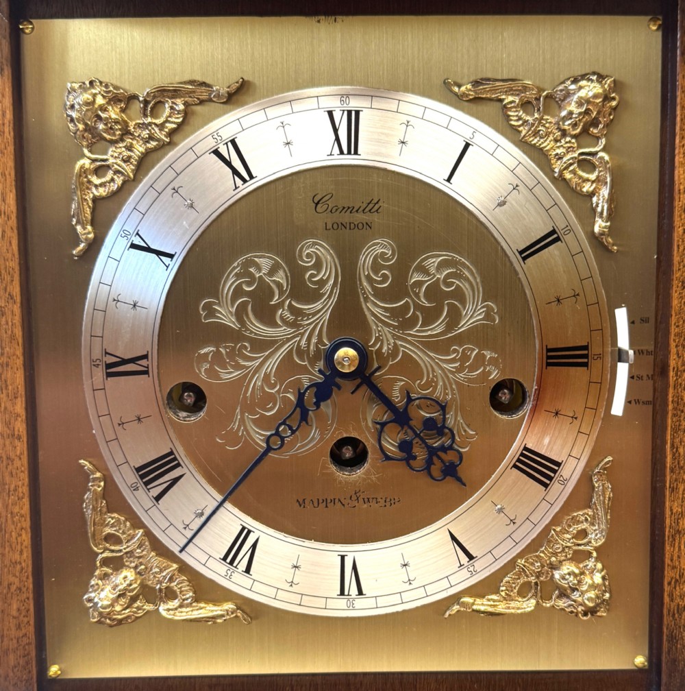 A burr walnut basket top mantel clock featuring an etched brass dial with Roman numerals, corner spandrels, side glass panels, and a top brass handle. View IV