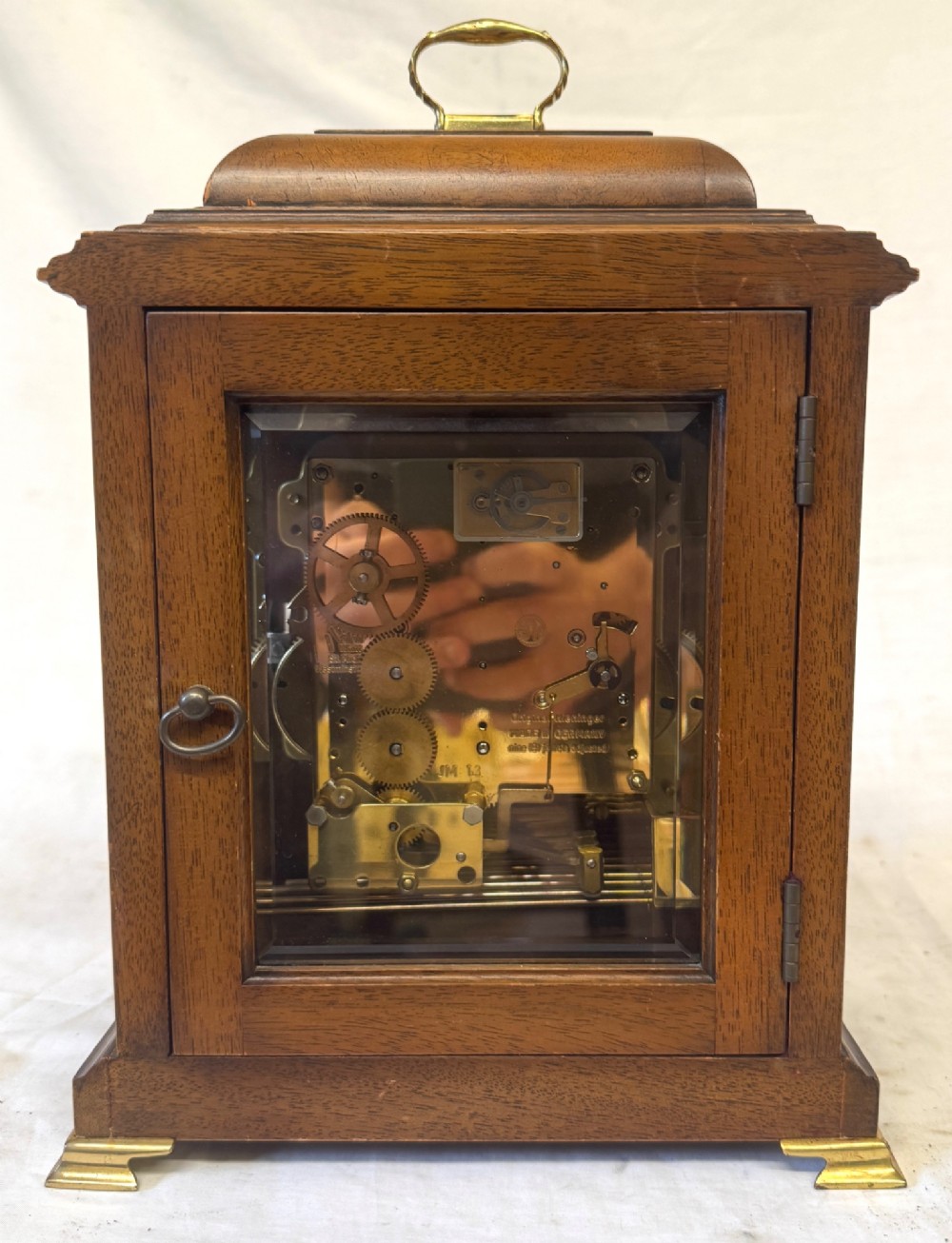 A burr walnut basket top mantel clock featuring an etched brass dial with Roman numerals, corner spandrels, side glass panels, and a top brass handle. View VIII