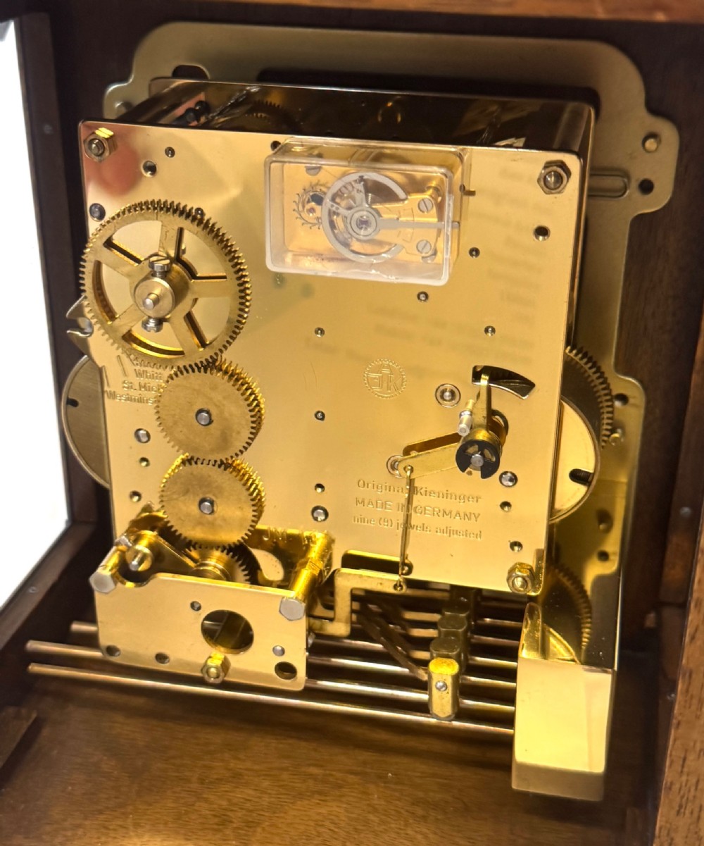 A burr walnut basket top mantel clock featuring an etched brass dial with Roman numerals, corner spandrels, side glass panels, and a top brass handle. View X