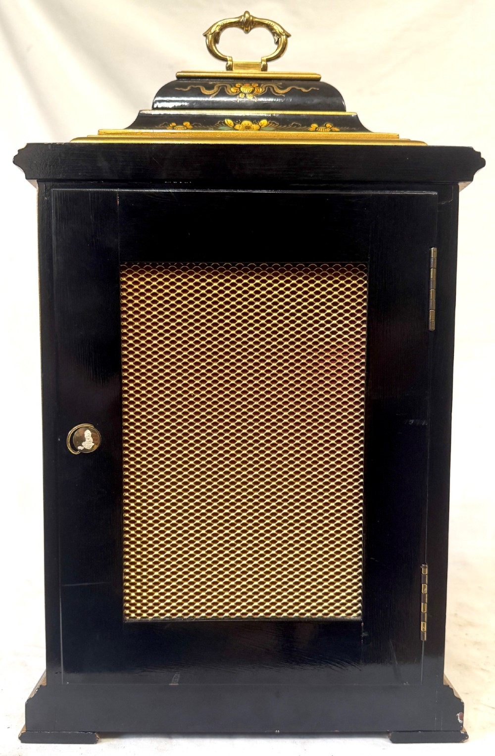 A black lacquered chinoiserie bracket clock featuring hand-painted gilt landscape scenes, a brass dial with Roman numerals, and a top brass carrying handle. View VIII