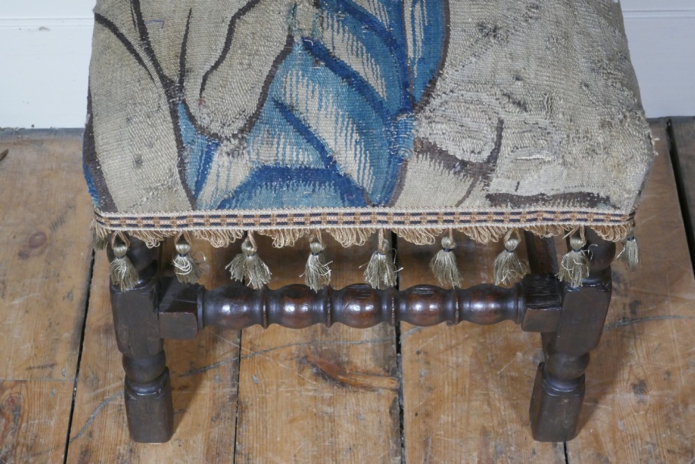 A pair of 17th-century oak back stools upholstered in tapestry fabric with tassel trim and turned legs. View IV